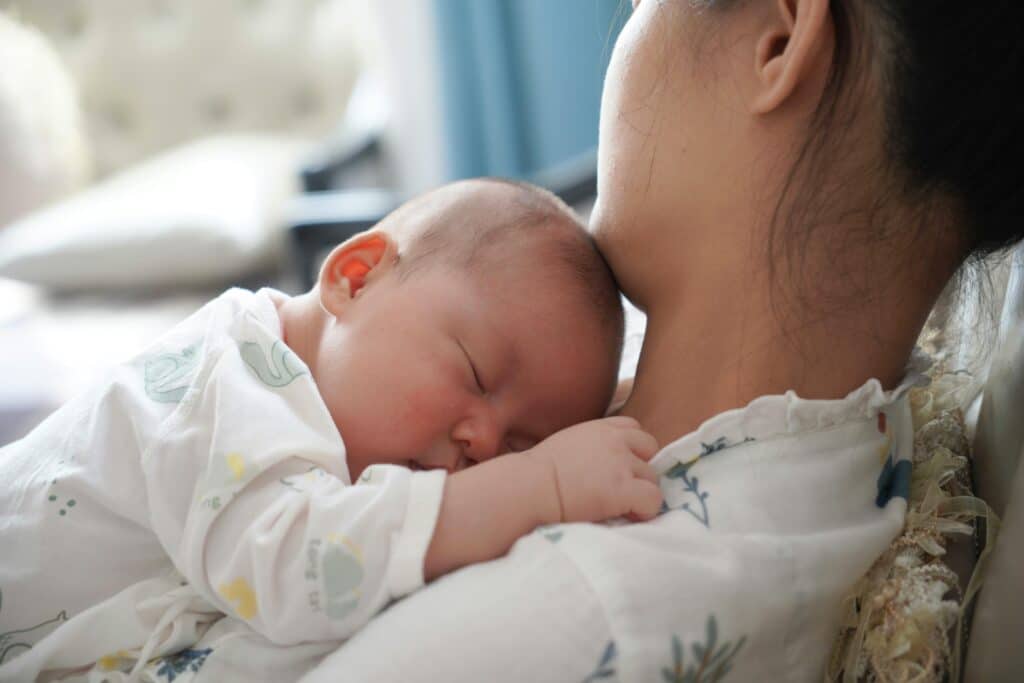 Woman Lying and Holding a Newborn Baby on Her Chest